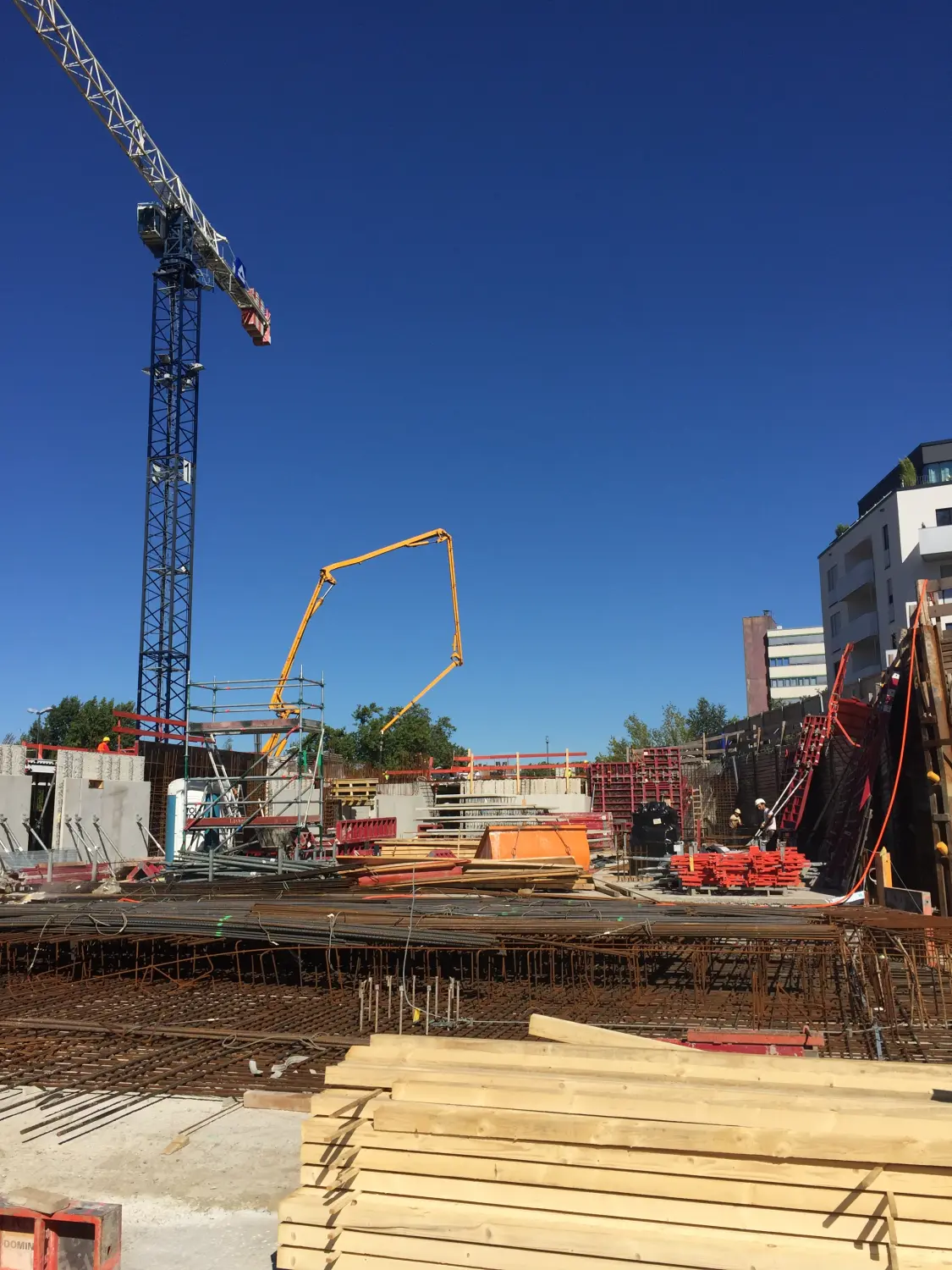 Fierle Baubetreuung - Baustelle mit mehreren Kränen, Gerüsten und Baumaterialien