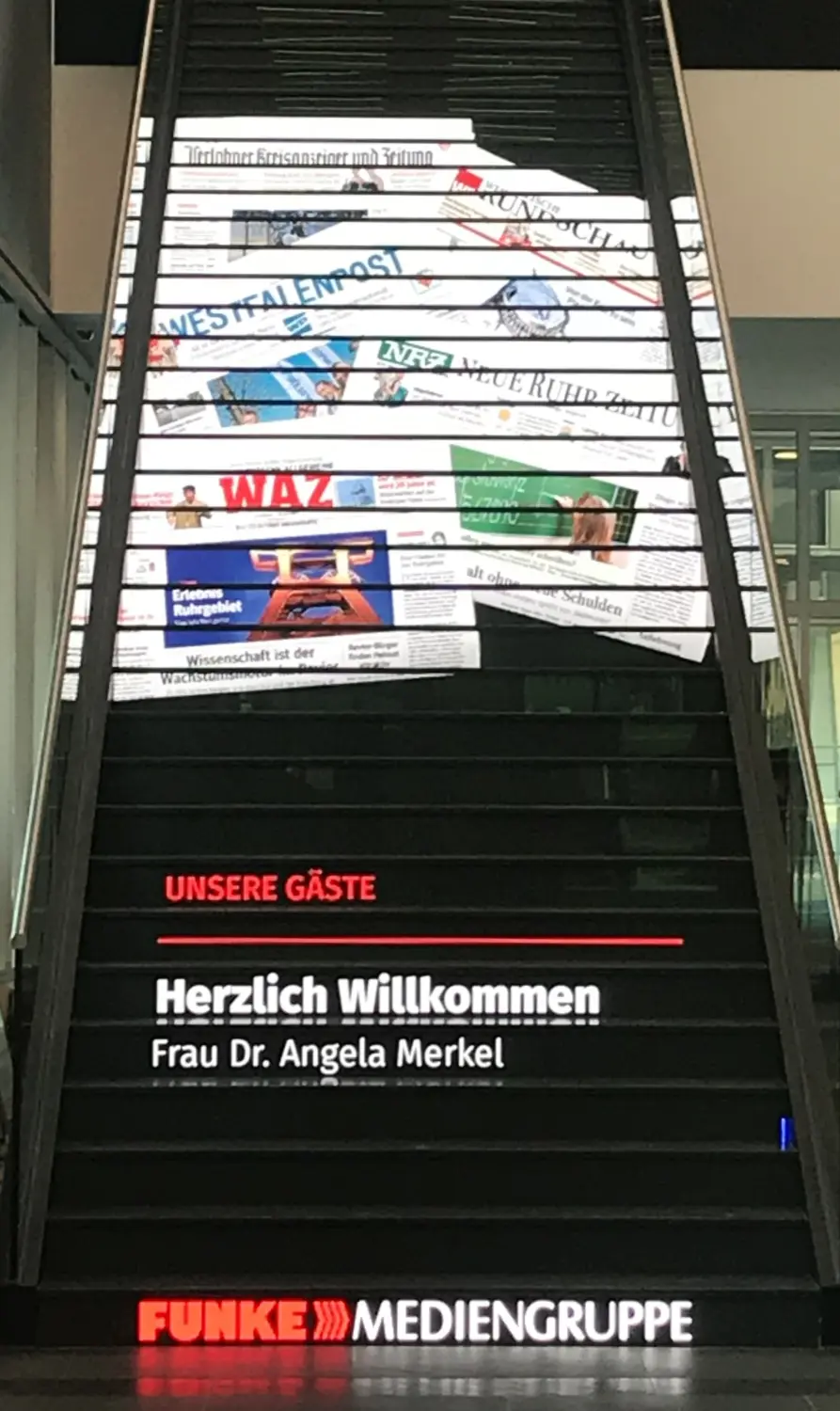 Fierle Baubetreuung – eine Treppe mit Zeitungsausschnitten auf den Setzstufen, einer Willkommensbotschaft und dem Logo der Funke Mediengruppe am Fuße