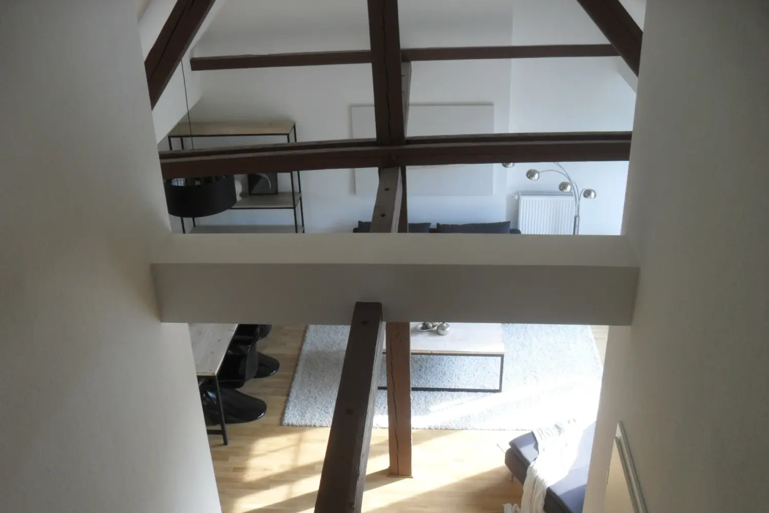 Fierle Baubetreuung – Innenansicht eines Hauses mit freiliegenden Holzbalken und minimalistischem Design