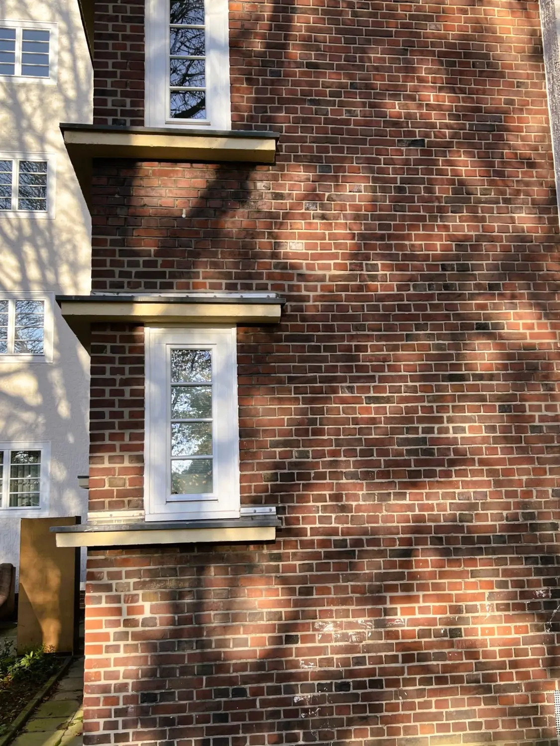 Fierle Baubetreuung – ein Wohngebäude im Bauhausstil mit vertikalen weißen Fenstern
