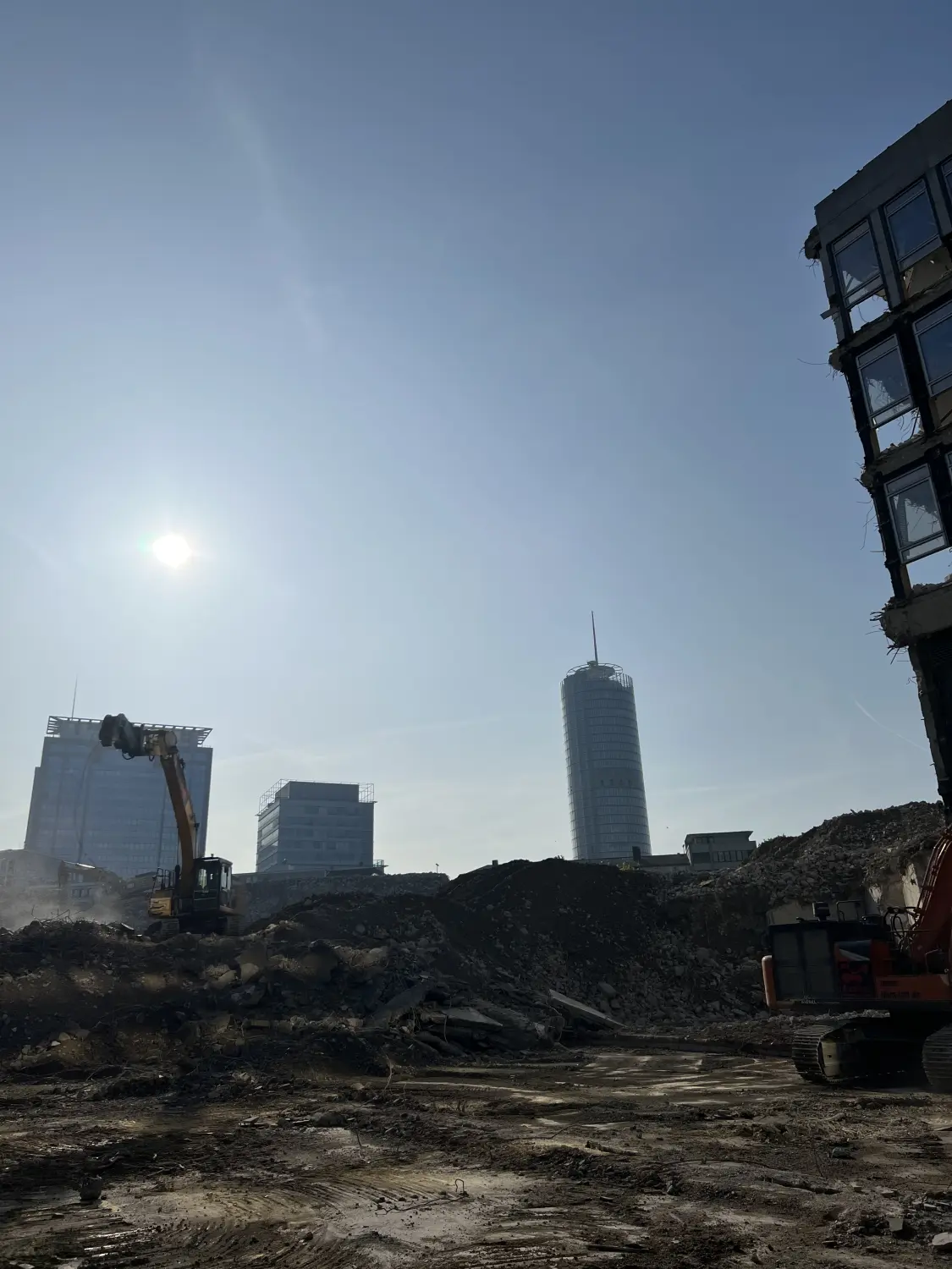 Fierle Baubetreuung - Baustelle mit mehreren Kränen, Gerüsten und Baumaterialien